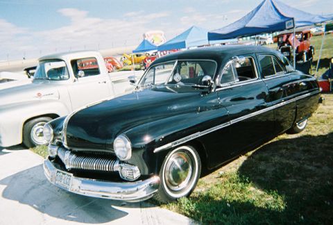 1972 Ford Ranchero - A classic black Mercury sedan is parked next to a silver pickup truck at an outdoor event.