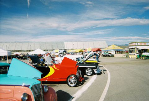 1972 Ford Ranchero - Multiple vehicles are on display at an outdoor car show under a partly cloudy sky.