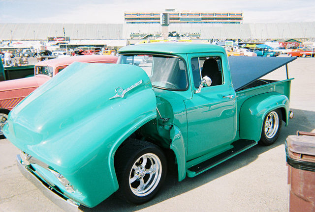 Teal 1956 Ford F-100 pickup truck with hood open, parked outdoors