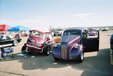1972 Ford Ranchero - Two unique cars are parked at an outdoor event, with tents and other vehicles in the background.