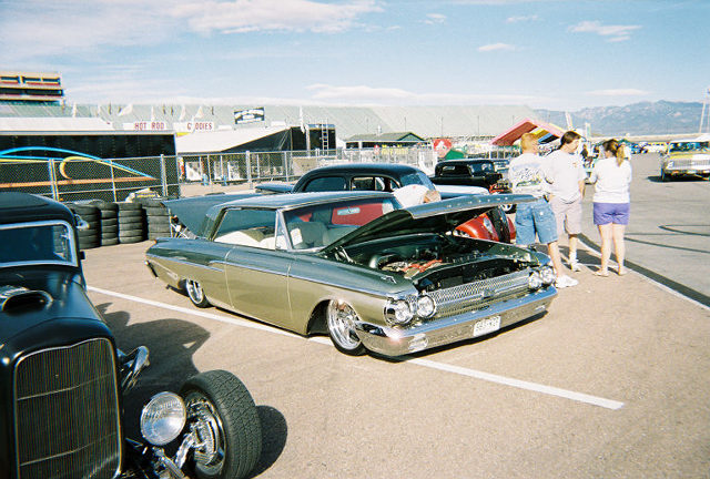 1960 Ford Falcon Ranchero with hood open, parked at an outdoor event