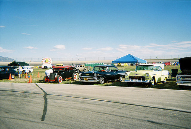Yellow 1955 Chevrolet Bel Air parked on grass with hood open