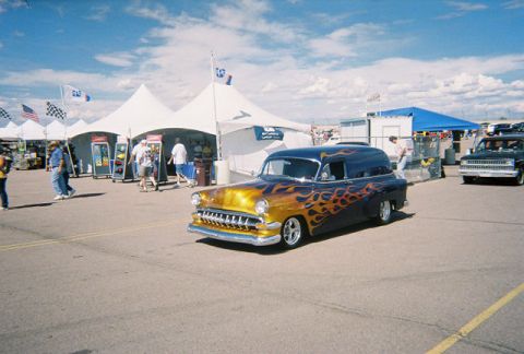 1972 Ford Ranchero - A custom panel van with flame graphics is parked at an outdoor event next to a pickup truck.