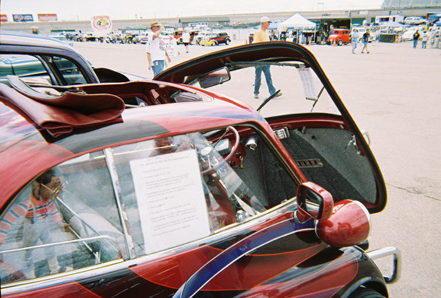 Red custom car interior with a sign on the window and a person reflected