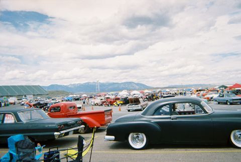 1972 Ford Ranchero - A gathering of classic cars under a cloudy sky, with mountains visible in the distance.