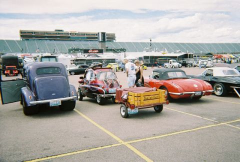 1972 Ford Ranchero - Several cars are parked in a lot with a grandstand in the background.