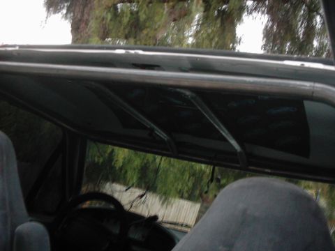 1978 Ford Bronco - The interior of the vehicle shows a roll cage installed above the seats and dashboard.