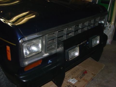 1985 Ford Ranger - Close-up of the front grille and headlights of a Ford Ranger, parked indoors.