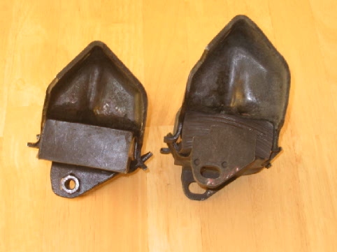 Two dark engine mounts on a wooden surface. Supermotors.net logo visible