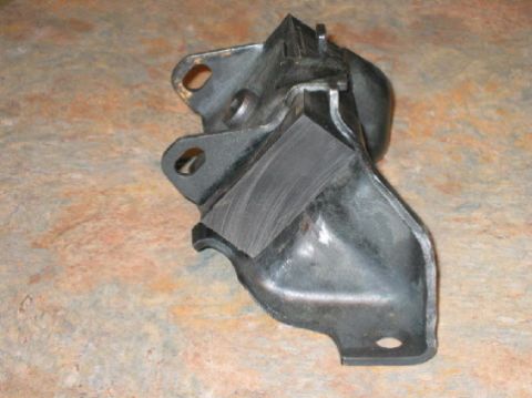 1978 Ford Mustang II - Engine mount bracket with rubber insulator shown on a textured surface.
