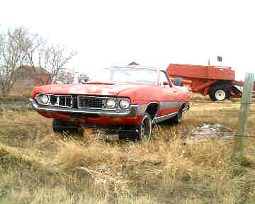 1967 Ford Ranchero - Red 1969 Ford Ranchero in a field with farm equipment.