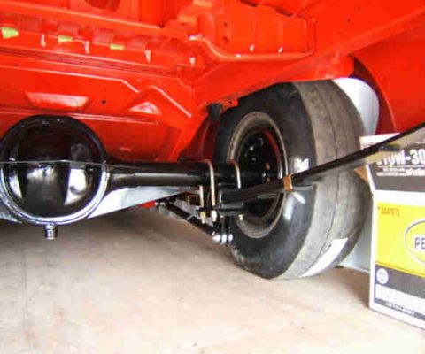 1967 Ford Ranchero - The rear axle and suspension components of a vehicle are visible, along with a box of oil.