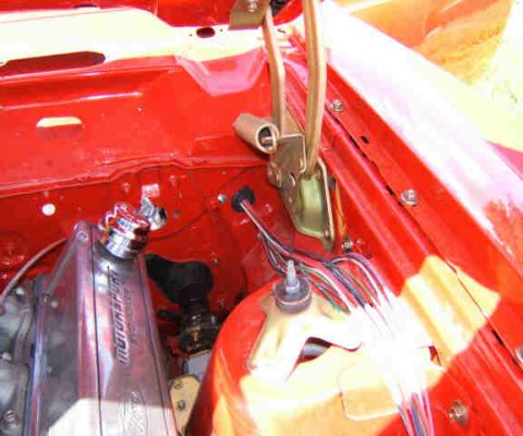 1967 Ford Ranchero - Close-up view of the engine bay of a red 1967 Ford Ranchero, showing the valve cover and radiator cap.