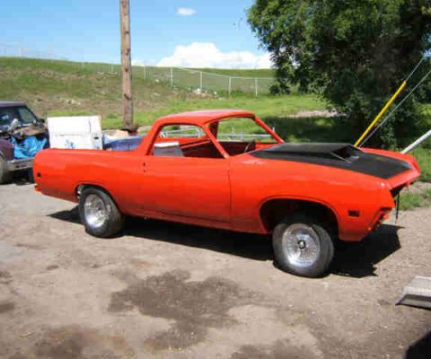 1967 Ford Ranchero - Orange Ford Ranchero project car with black hood scoop, parked outdoors.