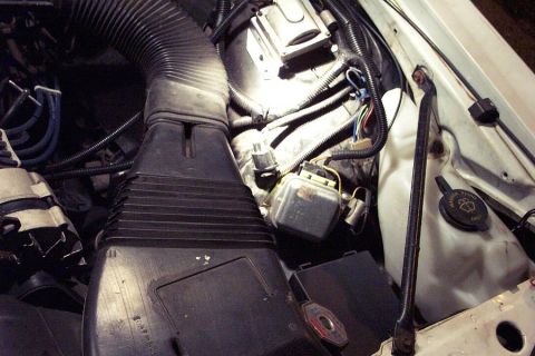 1985 Ford LTD Crown Victoria - Close-up view of engine bay components, including an air intake hose and various electrical parts.