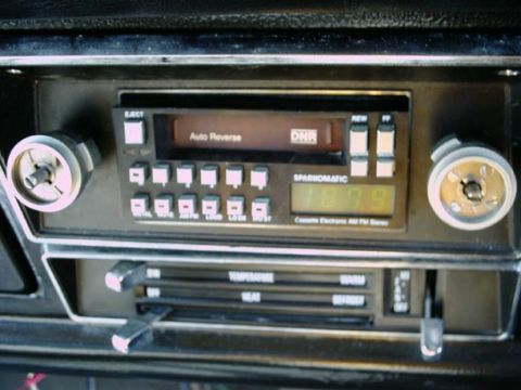 1971 Ford F-100 - Close-up of a car's dashboard showing a cassette player with 'Auto Reverse' and 'DNR' features, alongside climate control sliders.
