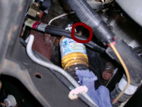2002 Ford F-250 - Close-up view of engine components, including a fuel filter and a bottle of yellow fluid.