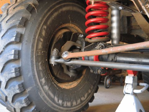 1995 Ford Bronco - The suspension and tire of a vehicle are visible, supported by a jack stand.
