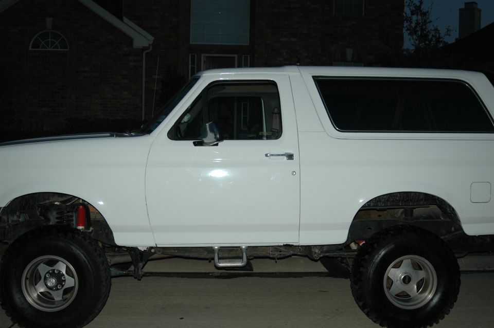 Side view of a white 1992 Ford Bronco with aftermarket wheels and tires