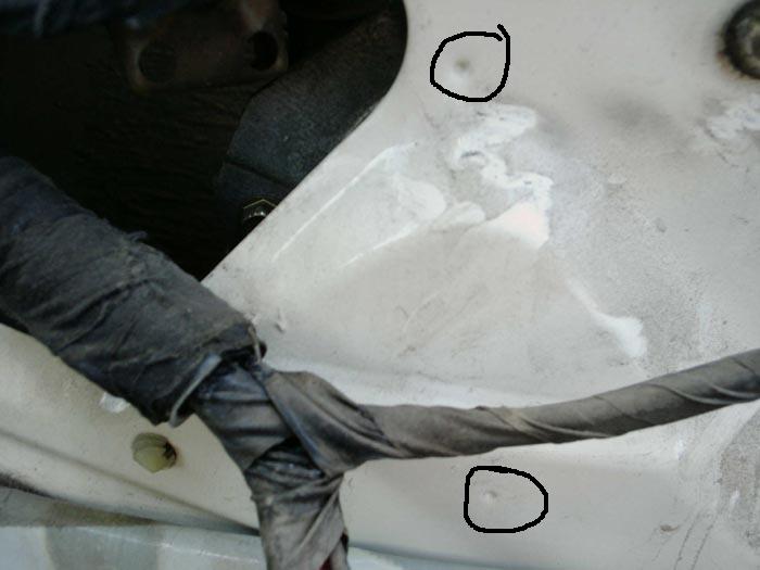 White vehicle body panel with two dimples circled in marker and wrapped wiring harnesses