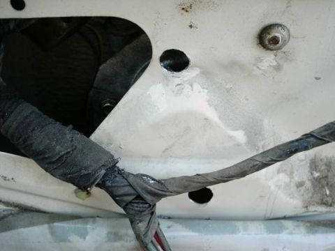 1988 Ford Bronco - Close-up of a vehicle's interior door panel, showing a damaged wiring harness.