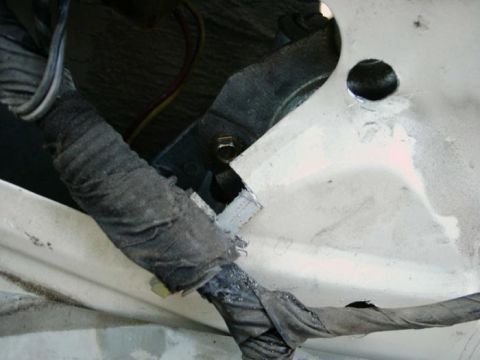 1988 Ford Bronco - Close-up view of a wiring harness and associated hardware, likely part of a vehicle's internal components.
