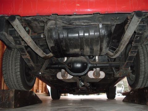 1978 Ford Mustang II - Undercarriage view of a red car, highlighting the rear suspension and exhaust system.