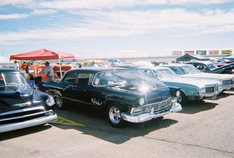 1972 Ford Ranchero - A black 1957 sedan is displayed with its hood open at an outdoor car show.