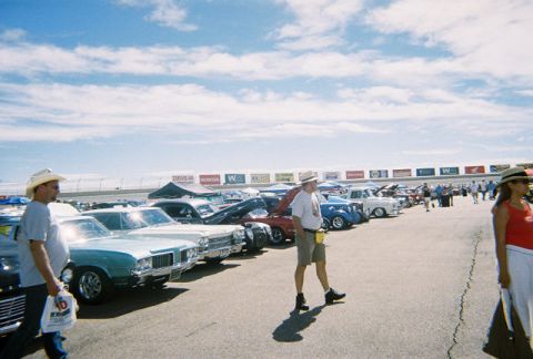 1972 Ford Ranchero - A sunny day at a car show with many classic vehicles on display and spectators milling about.