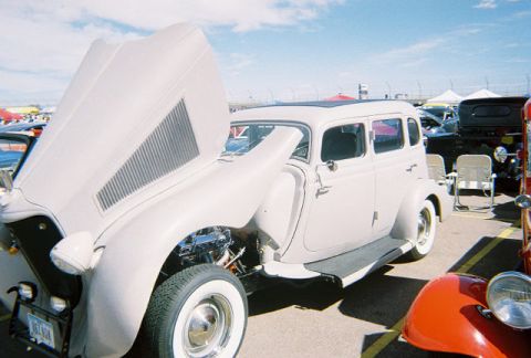 1972 Ford Ranchero - A vintage white sedan is displayed with its hood open at an outdoor event.
