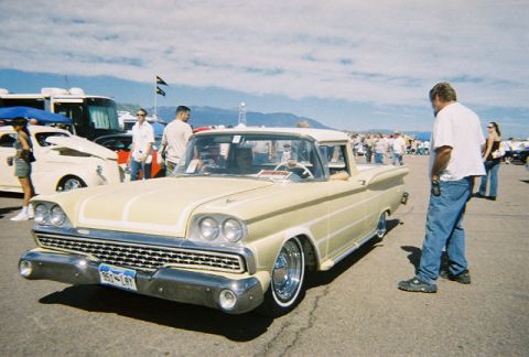 1972 Ford Ranchero - A yellow 1959 Ford Ranchero is parked at an outdoor event with people around it.