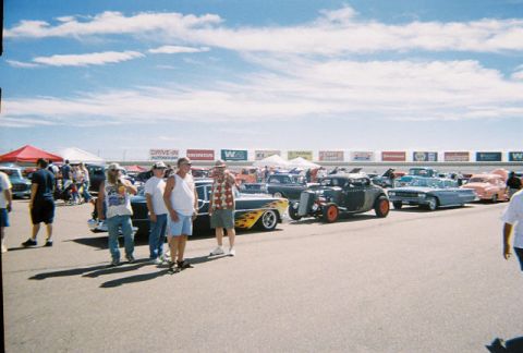 1972 Ford Ranchero - A car show event features a variety of classic vehicles and attendees under a partly cloudy sky.