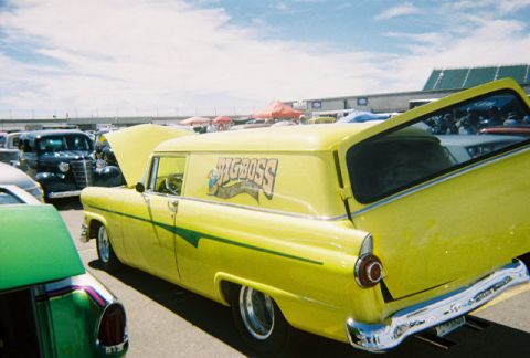 1972 Ford Ranchero - A bright yellow panel van with custom graphics is parked at an outdoor car show.