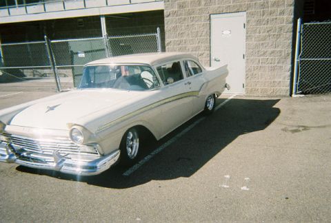 1972 Ford Ranchero - A classic 1957 Ford Fairlane is parked in a lot, casting a long shadow.