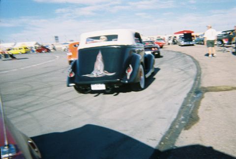 1972 Ford Ranchero - A dark blue convertible with a unique graphic on its trunk is seen from the rear at an outdoor event with other vehicles present.