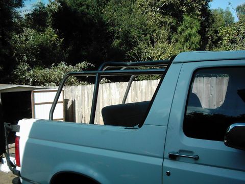 1978 Ford Bronco - This white SUV, likely a 1992 Ford Bronco, is equipped with an aftermarket roll cage.