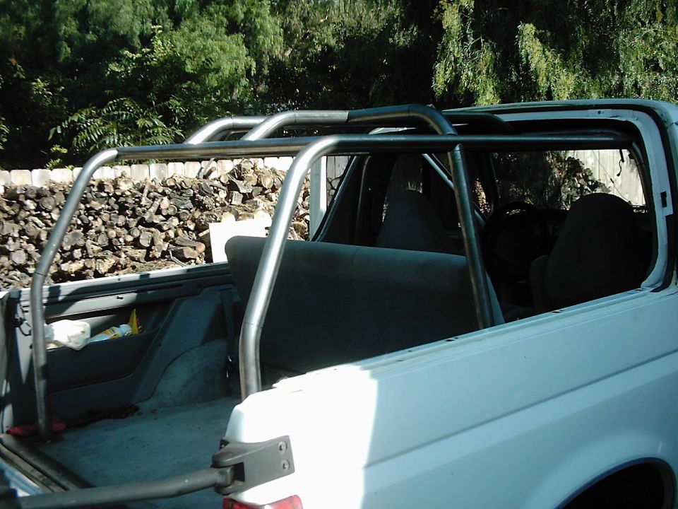White SUV interior with roll cage and grey seats, side view