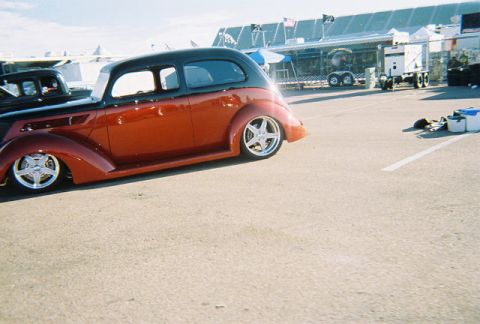 1972 Ford Ranchero - A two-tone hot rod sedan is parked next to another vehicle at an outdoor event.