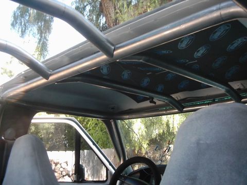 1978 Ford Bronco - The interior of the vehicle shows a custom roll cage and sound-deadening material on the roof.