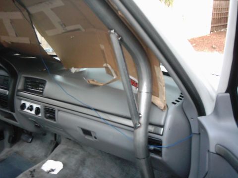 1978 Ford Bronco - The interior of a vehicle shows a custom roll cage installation and makeshift sunshades covering the windshield.