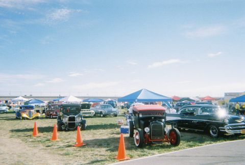 1972 Ford Ranchero - A sunny day at a car show with many classic vehicles on display under tents.