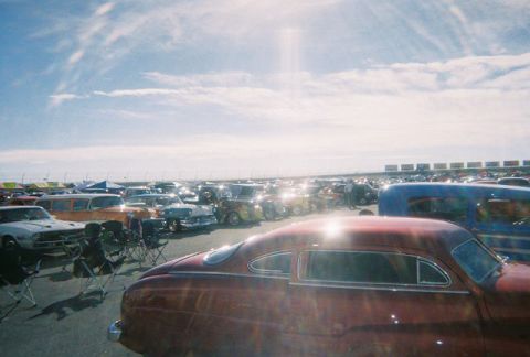1972 Ford Ranchero - A large gathering of classic cars fills a parking lot under a bright, partly cloudy sky.