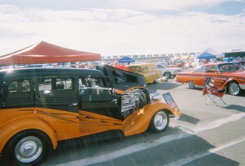 1972 Ford Ranchero - Custom hot rod sedan with exposed engine at an outdoor car show.