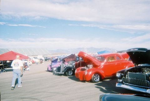 1972 Ford Ranchero - Hot rod cars are displayed at an outdoor event with mountains in the background.