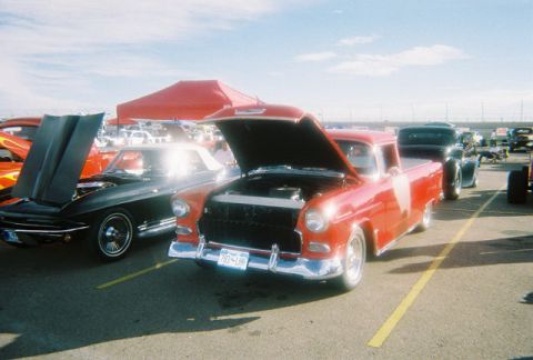 1972 Ford Ranchero - A red 1955 Chevrolet Cameo pickup truck is displayed with its hood open at an outdoor event.