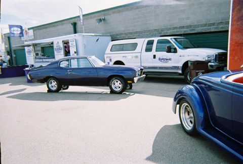 1972 Ford Ranchero - A dark purple 1970 Chevrolet Chevelle coupe is parked beside a white Ford F-series truck.