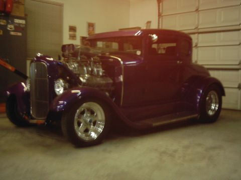 1978 Ford Bronco - Custom purple hot rod with a prominent V8 engine and chrome wheels sits in a garage.