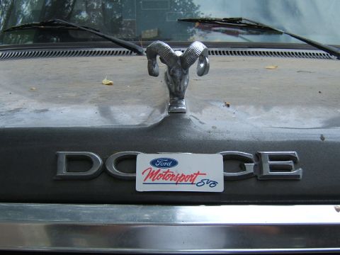 1988 Ford Bronco - Ram hood ornament adorns the hood of a Dodge vehicle, with a Ford Motorsport sticker placed over the emblem.