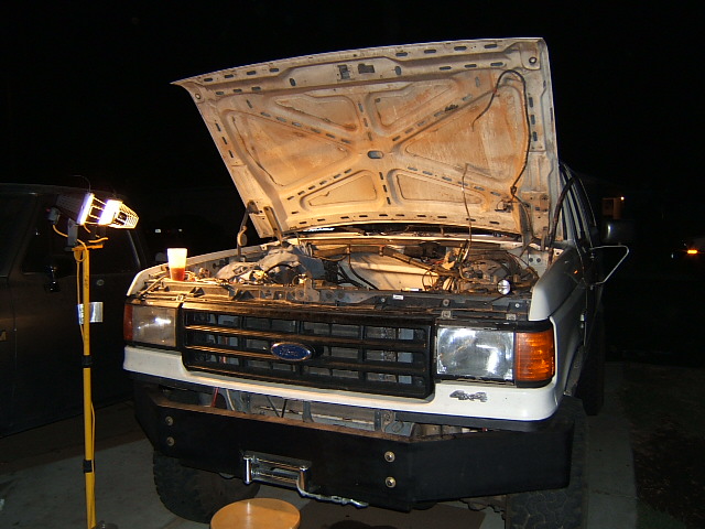 White 1988 Ford Bronco front view, hood open, engine exposed, winch on bumper