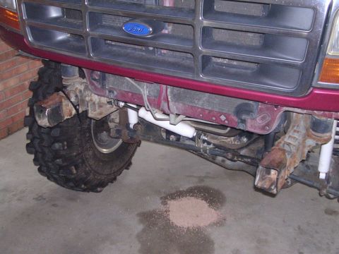 1995 Ford Bronco - Close-up of the front suspension and grille area of a Ford truck, showing off-road modifications.